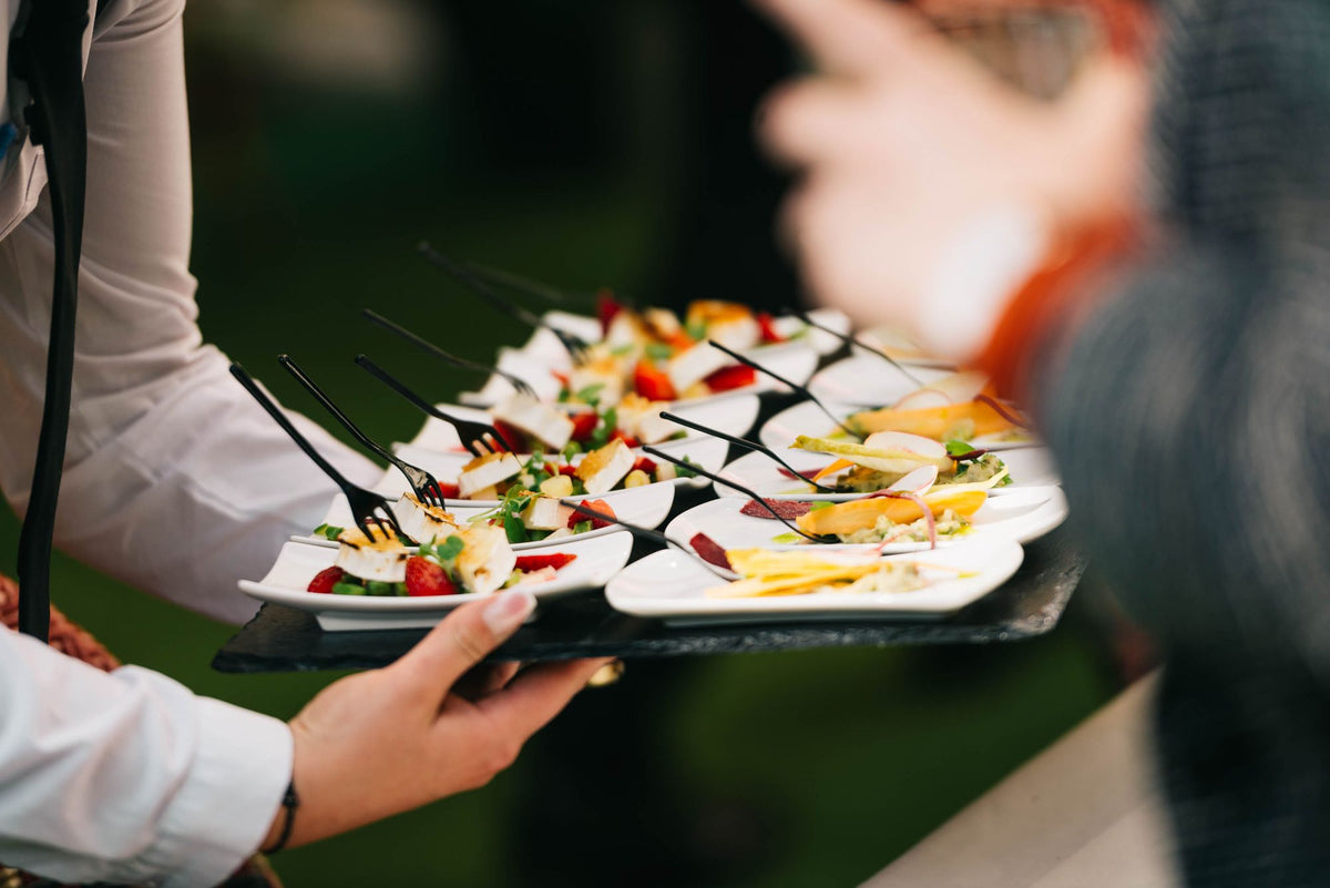 Bediening serveert hapjes op een event