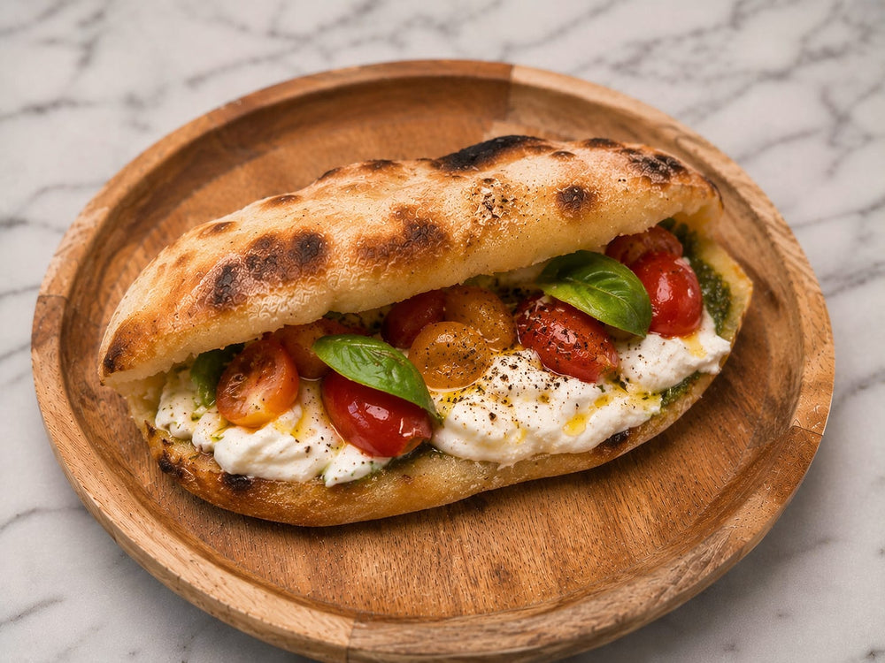Calzone Caprese: Italiaans broodje met burrata, cherrytomaatjes, basilicum en pesto