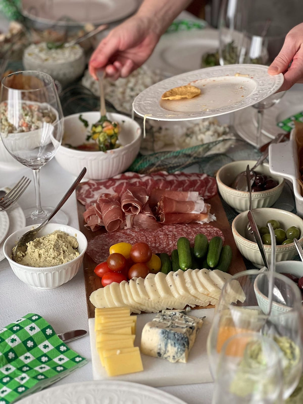 Gasten scheppen op bij een buffet met vleeswaren, kaas en salades