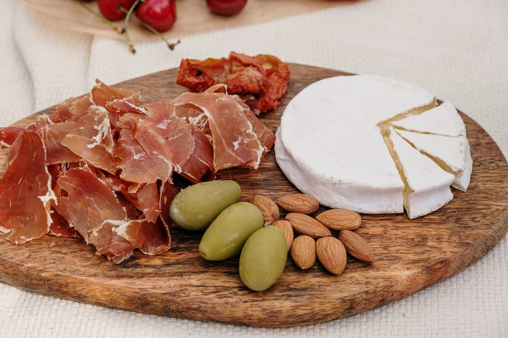 Plank met parmaham, brie, olijven en amandelen