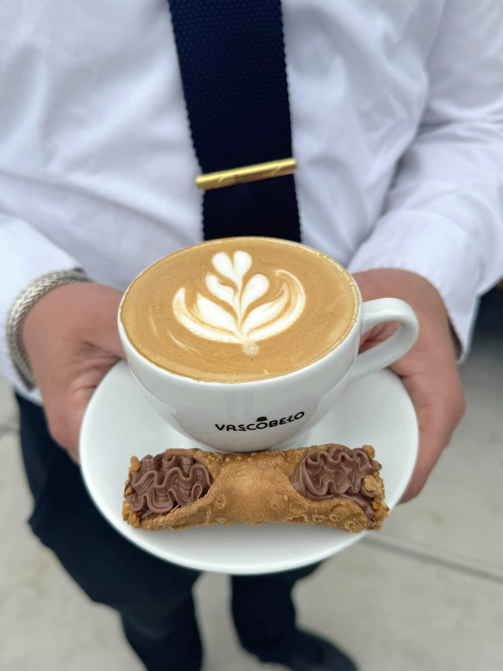 Cappuccino met latte art en een cannoli