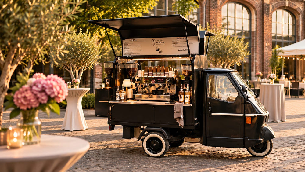 Koffiebar in een zwarte Piaggio op een buitenevent bij zonsondergang