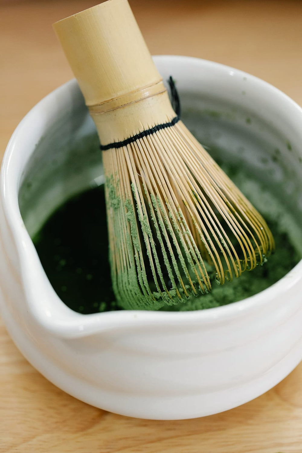 Matcha being whisked with a bamboo whisk