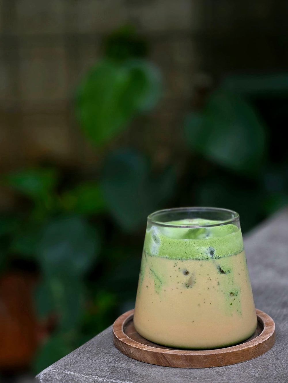Iced matcha latte op een houten onderzetter